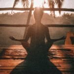 woman doing yoga meditation on brown parquet flooring